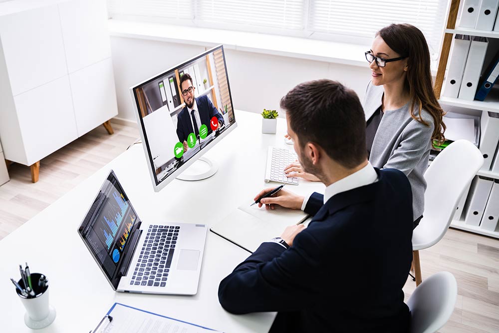 Co-worker are looking on a monitor during a video meeting